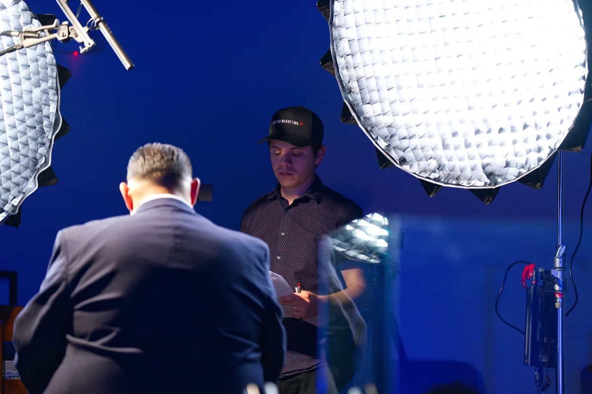 Dan operating a camera with studio lighting during content production
